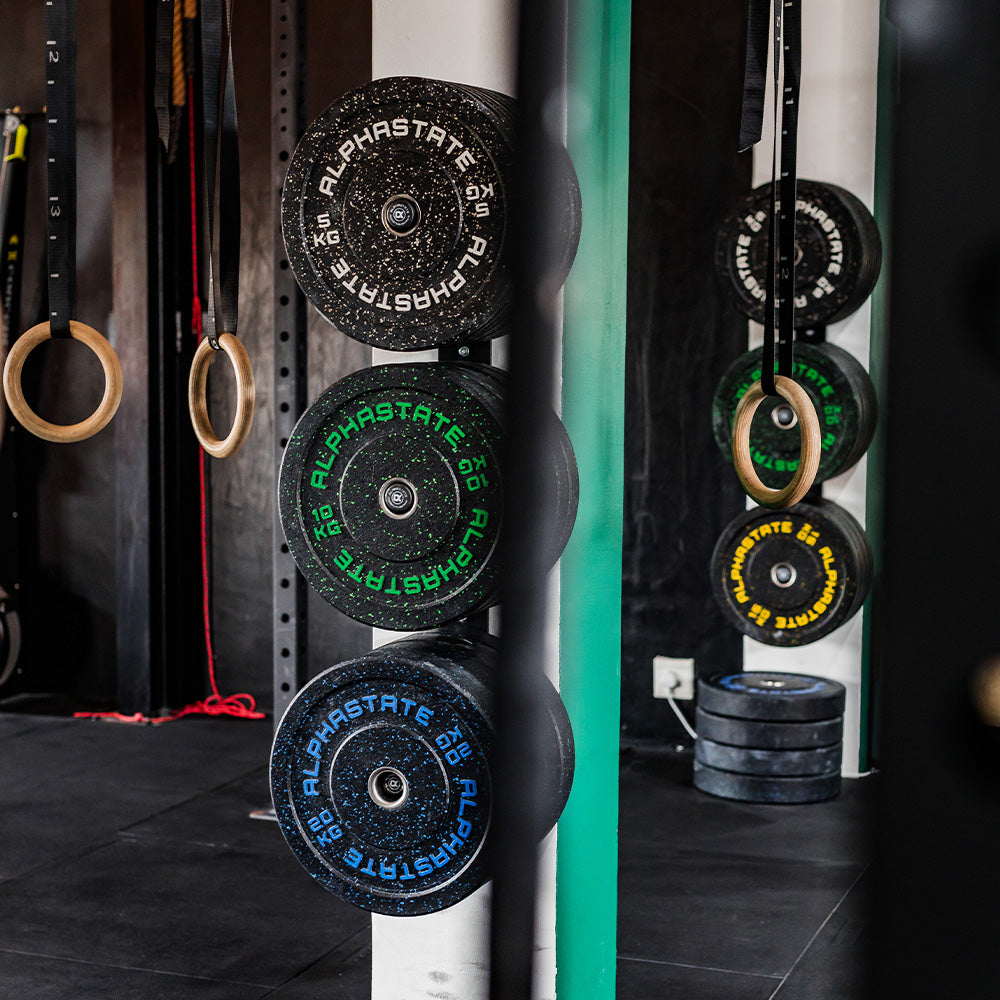 AlphaState Speckled Weights on Wall-mounted Storage i a Gym.